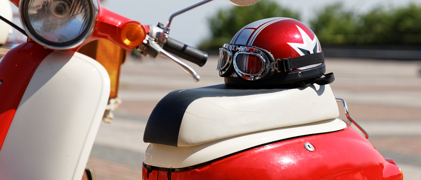 Closeup of red and white moped with helmet on the seat